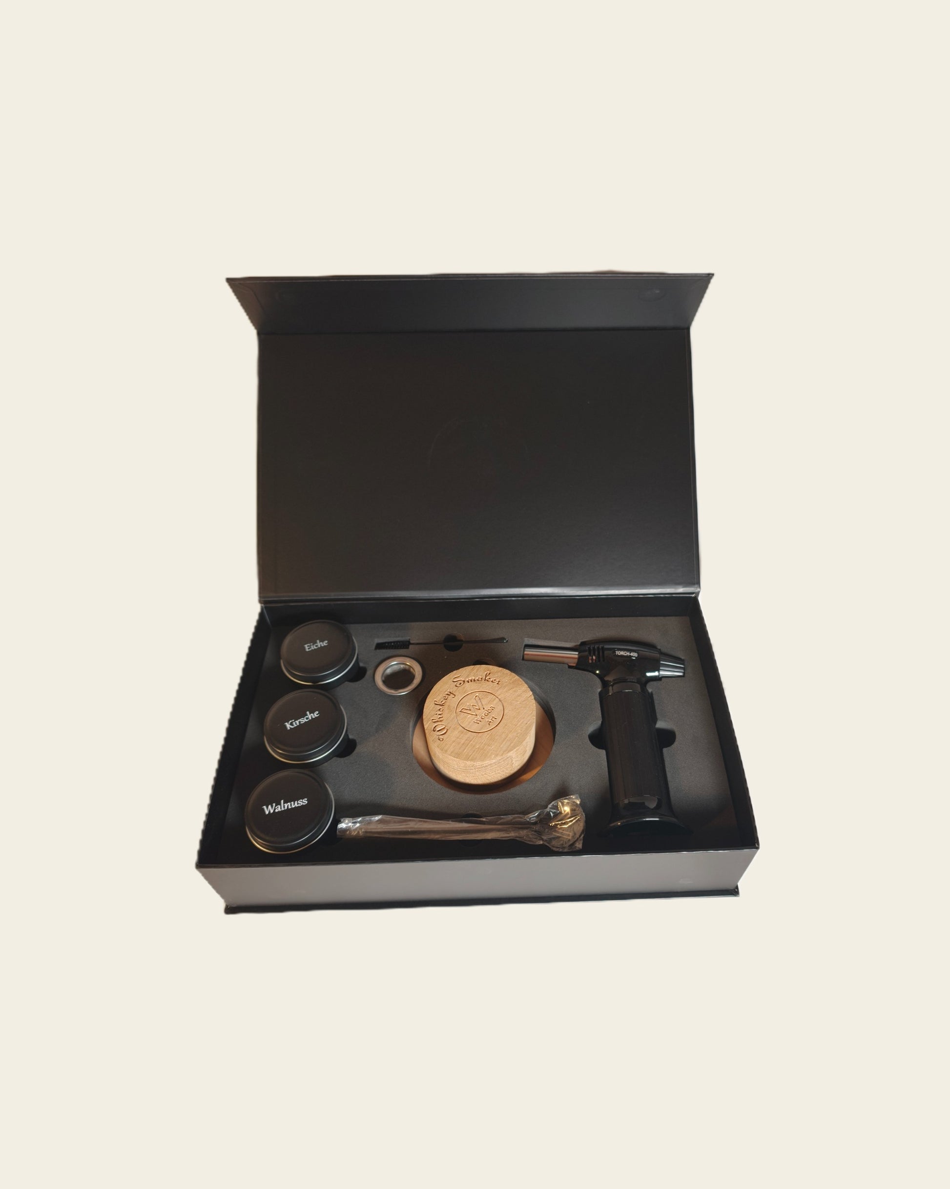Whiskey- und Cocktail Smoker Set mit drei Holzsorten zur Räucherung, einem Löffel, dem Smoker aus Holz, einem Feuerzeug und einem kleinen Sieb in einer passenden Box.