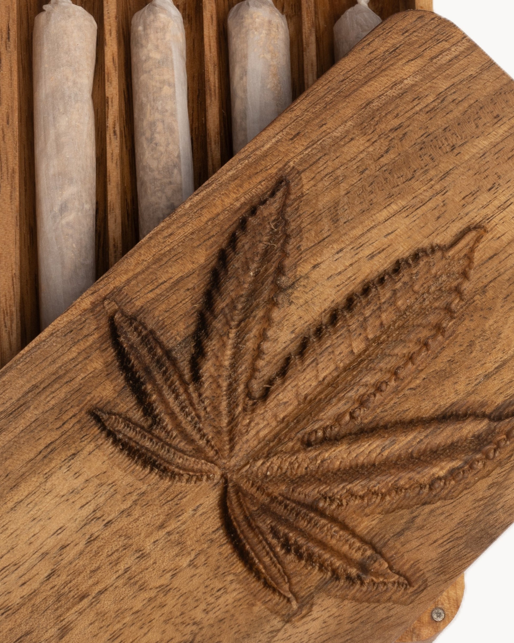 Nahaufnahme des Deckels mit Hanfblatt-Gravur einer Holz-Box mit vier Kammern für jeweils einen Joint mit magnetischem Deckel verschließbar