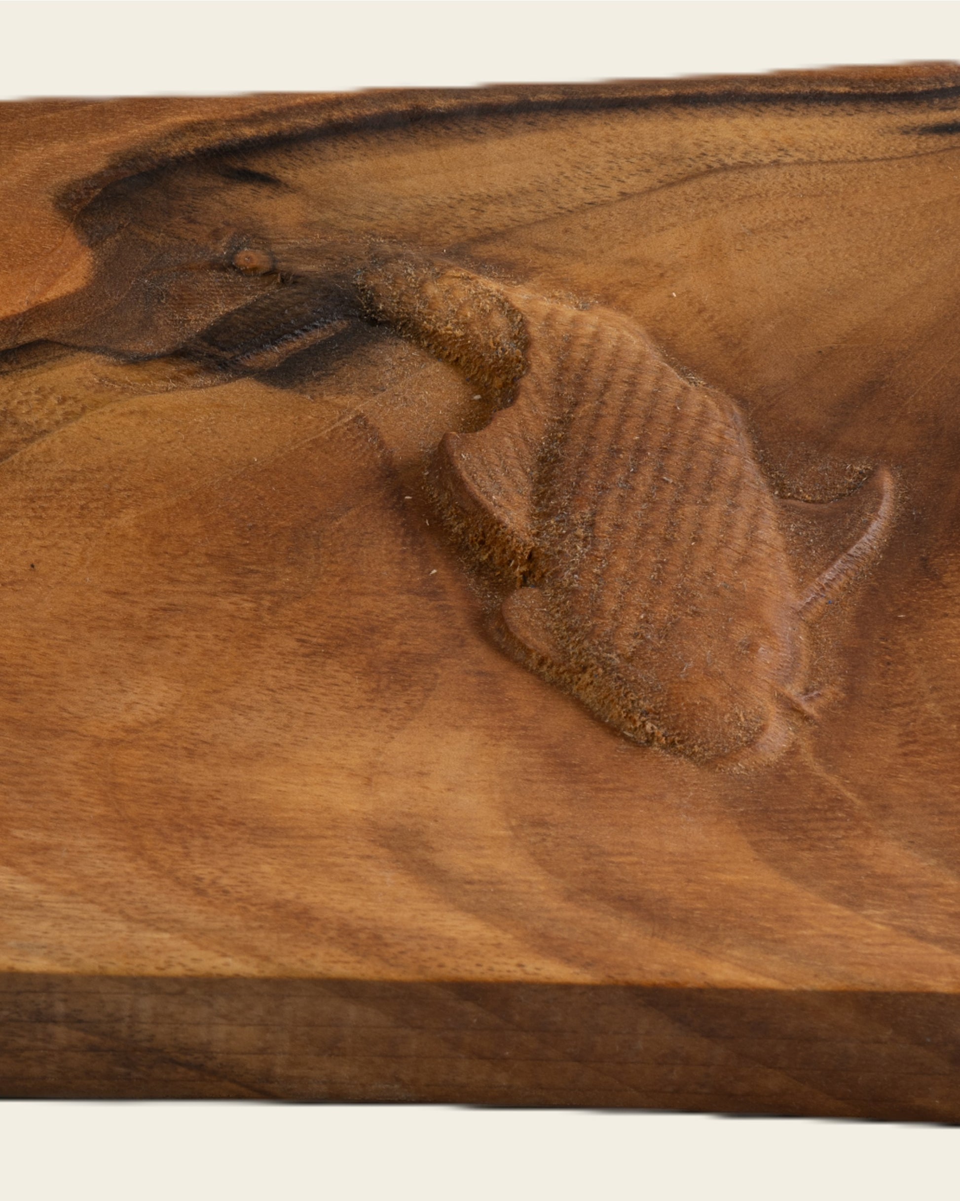 Nahaufnahme eines Sushi-Servierbretts aus Holz mit eingraviertem Fisch
