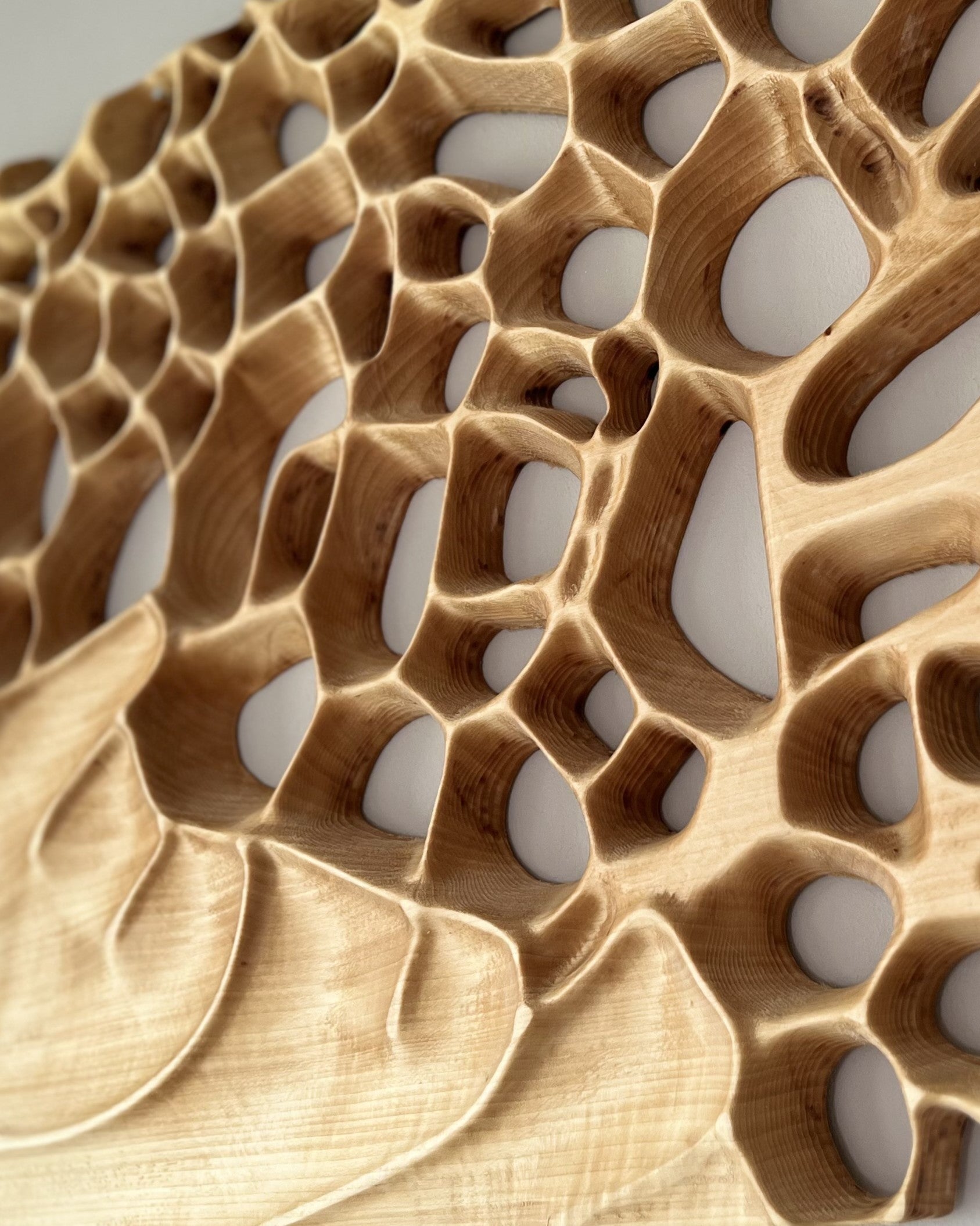 Nahaufnahme eines modernen Wandbild aus Holz mit organischen Formen und Löchern